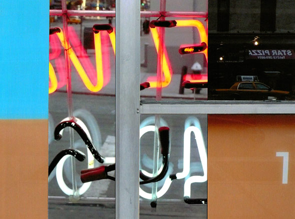 Backwards neon letters and numbers framed by orange and turquoise quadrants.